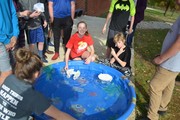 Students racing handmade boats in pool