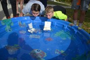 Students racing handmade boats in pool