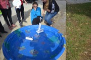 Students racing handmade boats in pool