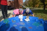 Students racing handmade boats in pool