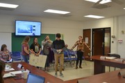 students with posters in front of board