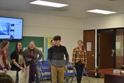 students with posters in front of board