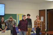 students with posters in front of board