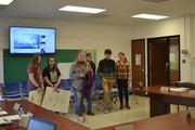 students with posters in front of board