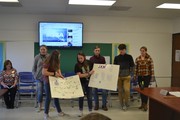 students with posters in front of board