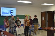 students with posters in front of board